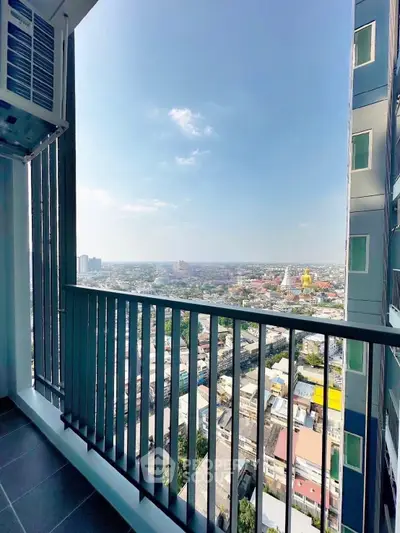 Stunning high-rise balcony view overlooking vibrant cityscape under clear blue skies.