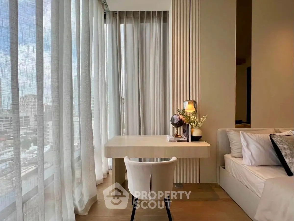 Elegant study nook with modern desk and chair, surrounded by floor-to-ceiling windows offering city views.