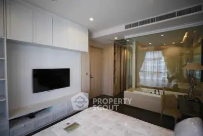 Modern bedroom with glass partition and built-in TV unit, featuring sleek design and ample storage.