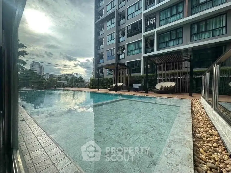Luxurious apartment complex with stunning pool and modern architecture, perfect for urban living.