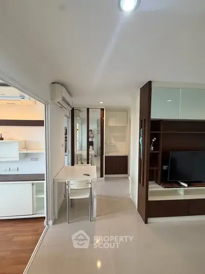 Modern apartment interior with sleek design, featuring a compact living area and built-in storage solutions.