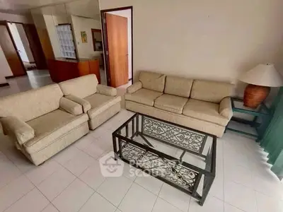 Spacious living room with elegant beige furniture and glass coffee table, perfect for relaxation.