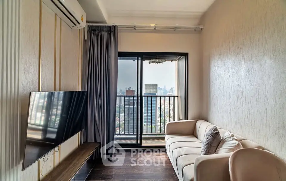 Modern living room with city view balcony, stylish sofa, and mounted TV in a high-rise apartment.