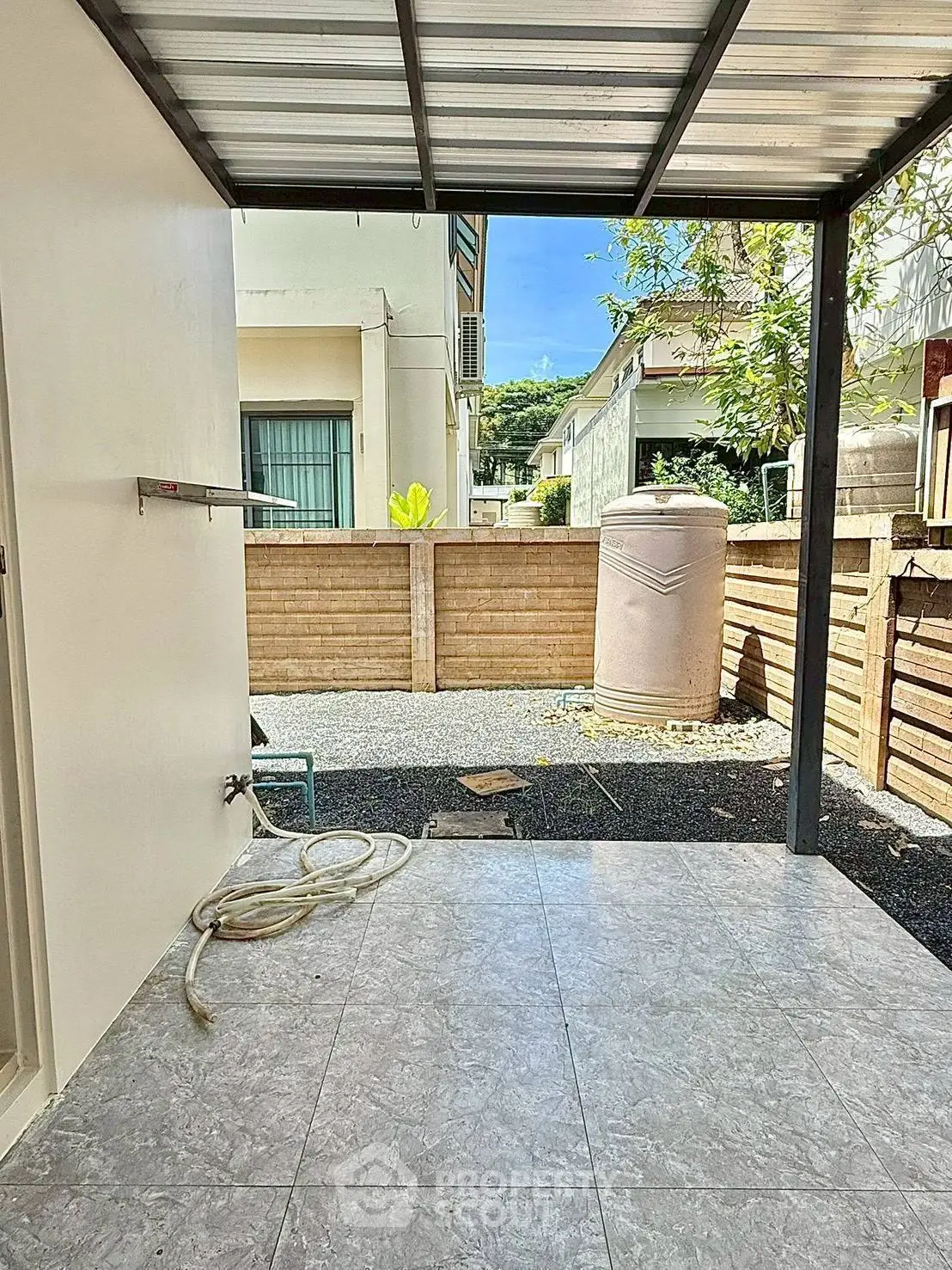 Charming outdoor space with tiled flooring and partial roof, perfect for relaxation.