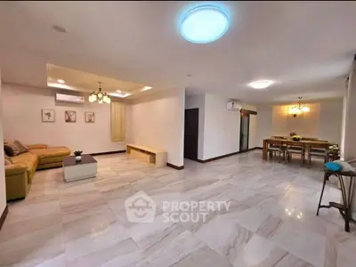 Spacious open-plan living and dining area with modern lighting and tiled flooring.