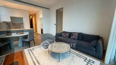 Modern living room with stylish furniture and open kitchen layout in luxury apartment.
