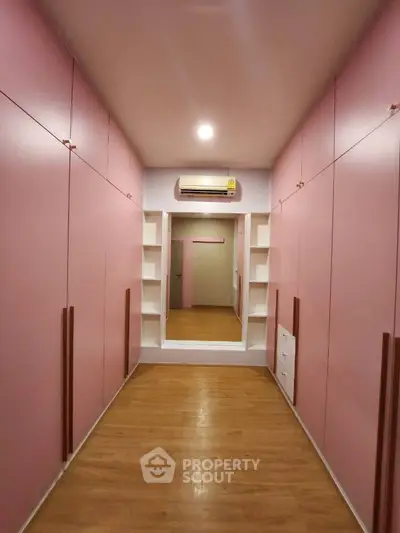 Spacious pink walk-in closet with ample storage and modern design