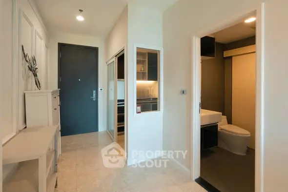 Modern apartment entrance with sleek bathroom and storage area