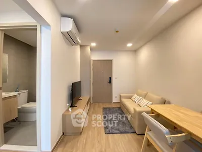 Modern living room with cozy sofa, TV, and dining area in a stylish apartment.