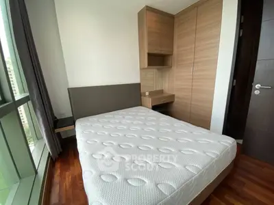 Modern bedroom with large window and built-in wardrobe