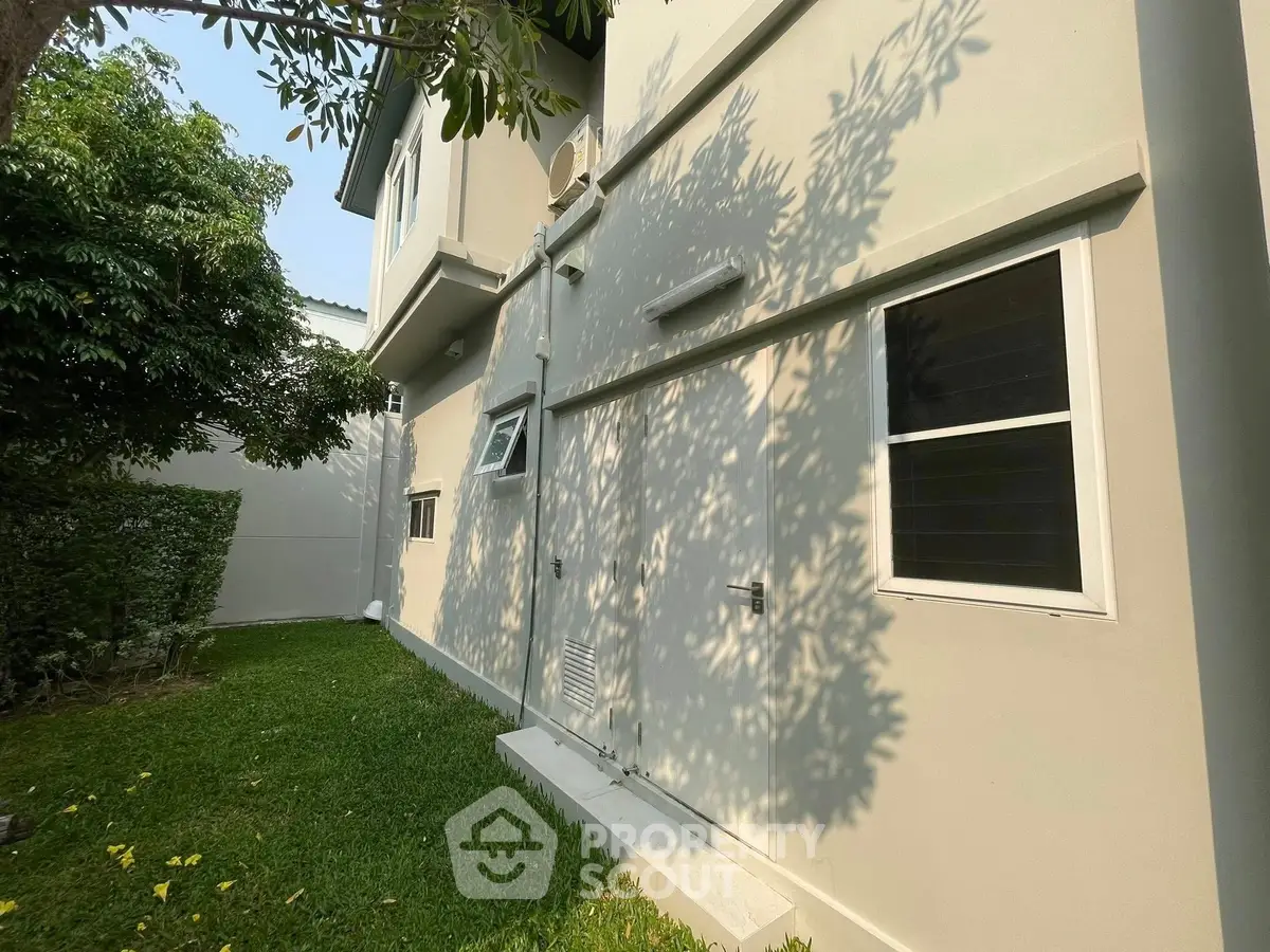 Modern residential building exterior with lush garden and natural light.