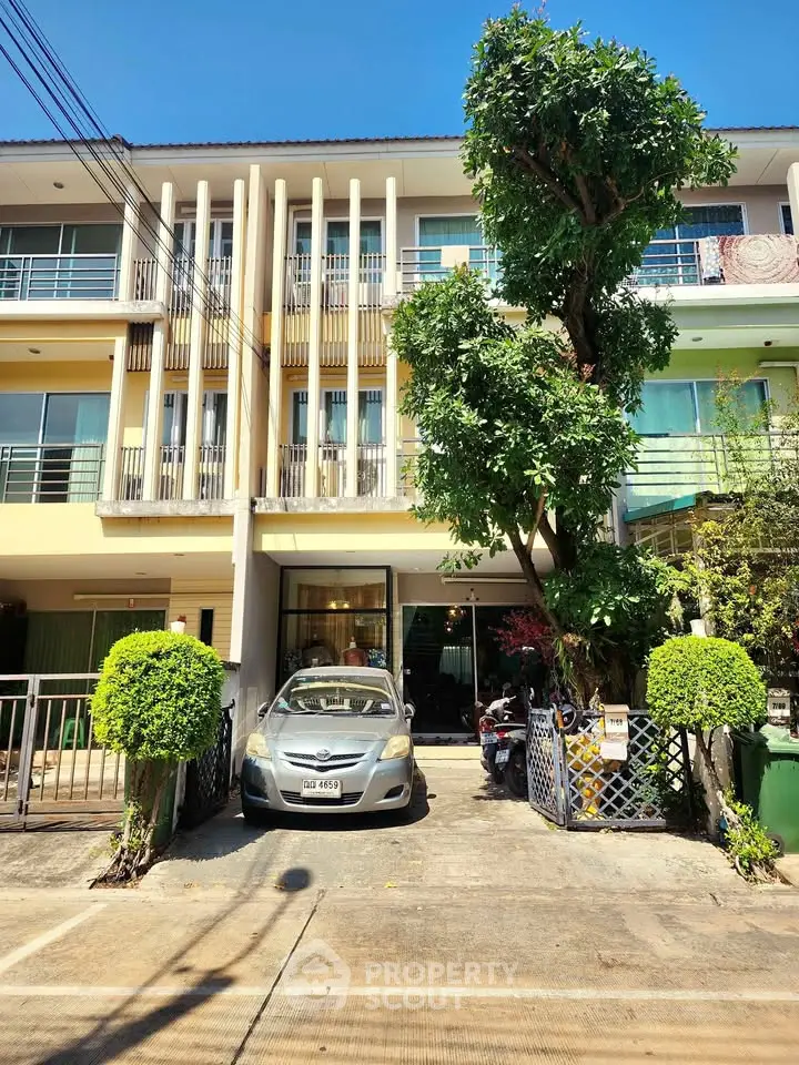 Modern townhouse with parking space and lush greenery in a vibrant neighborhood.