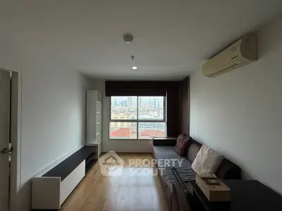 Spacious living room with city view, modern sofa, and air conditioning in a high-rise apartment.