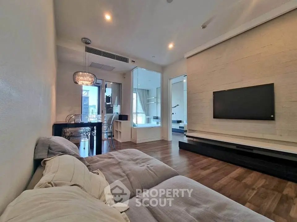 Modern living room with stylish decor and open layout, featuring a cozy sofa and wall-mounted TV.