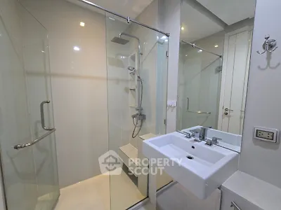 Modern bathroom with glass shower enclosure and sleek sink design
