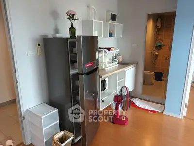 Modern kitchen with sleek appliances and open layout, featuring a stylish fridge and organized shelving.