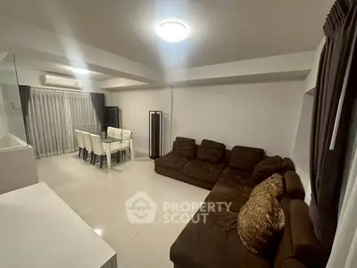 Spacious modern living room with elegant dining area and plush seating.