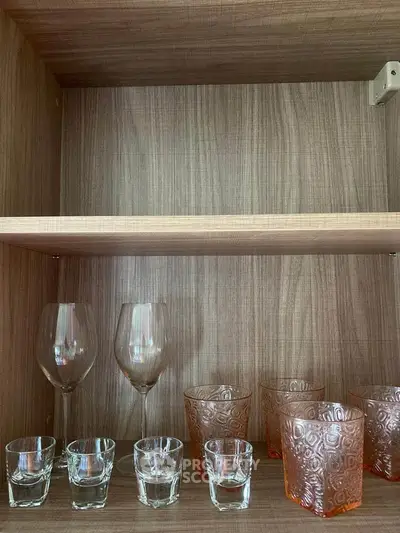Elegant wooden cabinet with assorted glassware, perfect for stylish kitchen or dining room storage.
