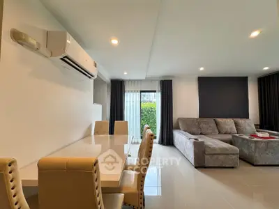 Modern living room with dining area and stylish furniture in a bright, open space.
