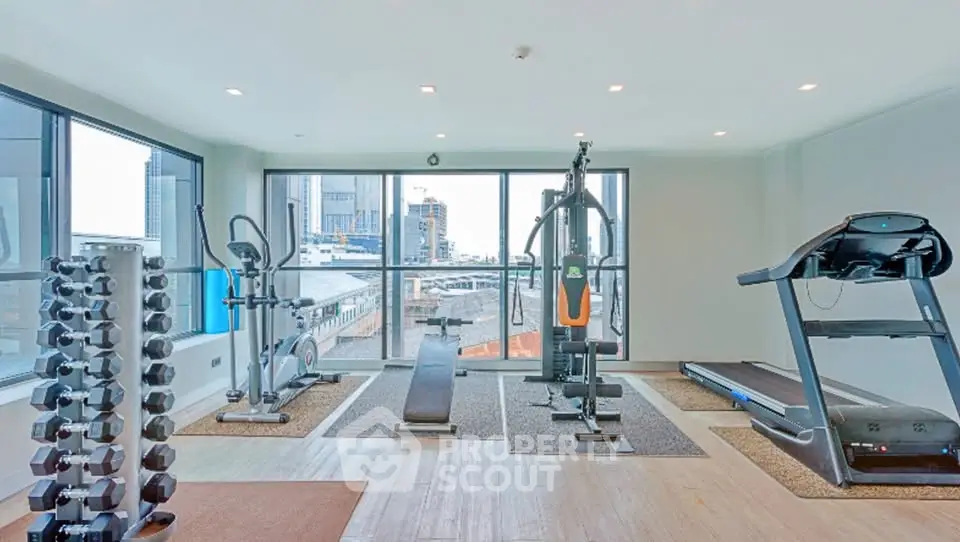 Modern gym with city view, featuring state-of-the-art fitness equipment and large windows.