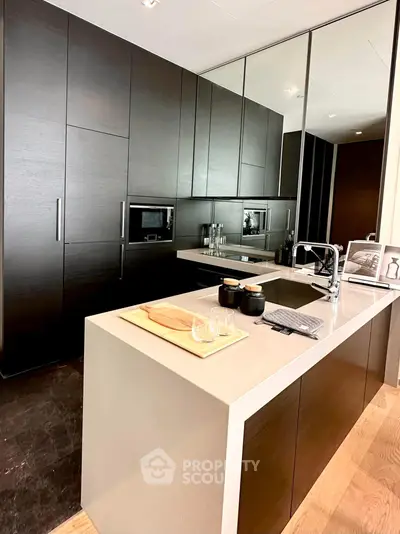 Modern kitchen with sleek dark cabinetry and integrated appliances