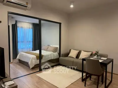 Modern studio apartment with cozy living area and glass partitioned bedroom.