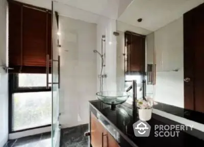 Modern bathroom with glass shower and sleek black countertop