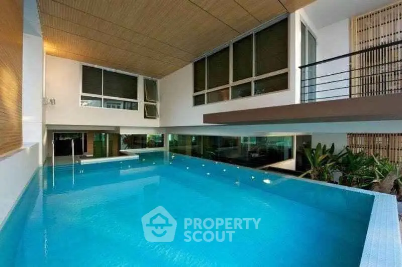 Luxurious indoor pool with modern design and large windows in a contemporary building.
