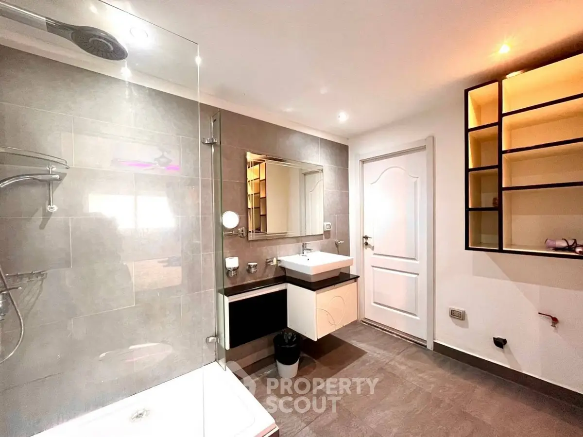 Modern bathroom with glass shower and stylish vanity in contemporary home.