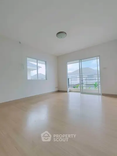 Spacious empty room with large windows and balcony access, perfect for customization.