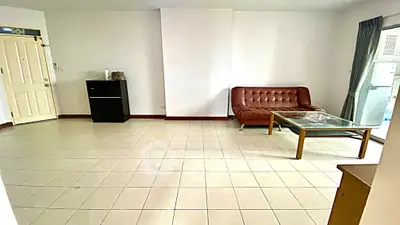 Spacious living room with tiled floor and modern furniture in a bright apartment.