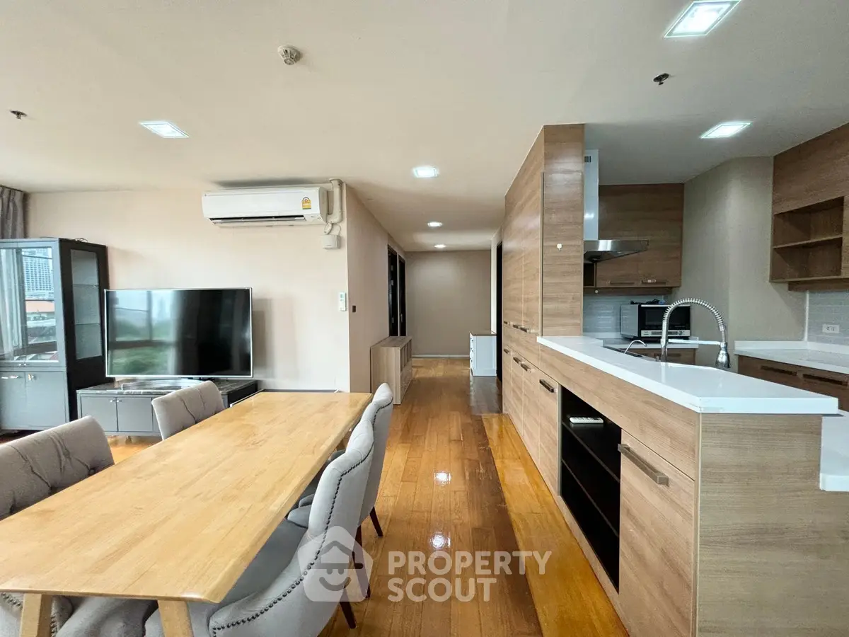 Spacious open-plan kitchen and dining area with modern wooden finishes and ample natural light.