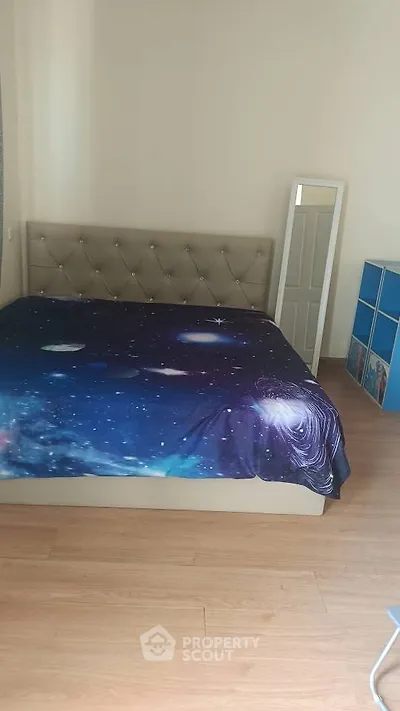 Spacious bedroom with galaxy-themed bedding and modern decor