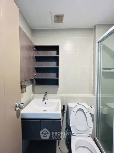 Modern bathroom with sleek fixtures and glass shower enclosure.
