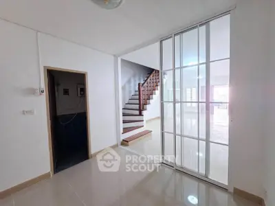 Spacious modern interior with sliding glass doors and elegant staircase