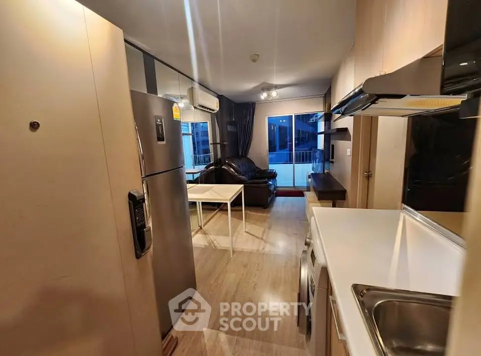 Modern open-plan living room with kitchen and balcony view