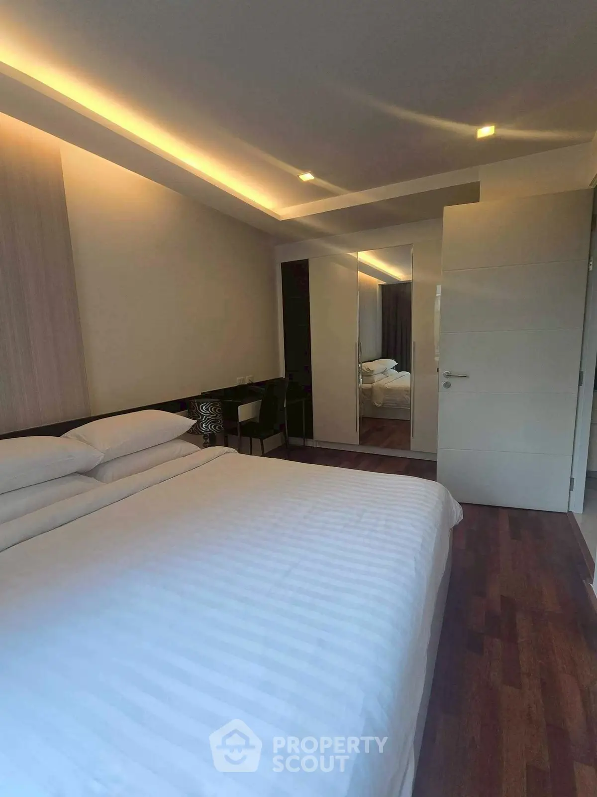 Modern bedroom with elegant lighting and wooden flooring