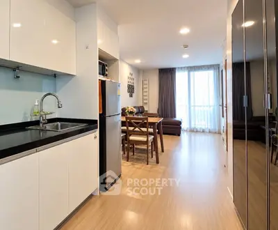 Modern open-plan kitchen and living room with sleek design and ample natural light.