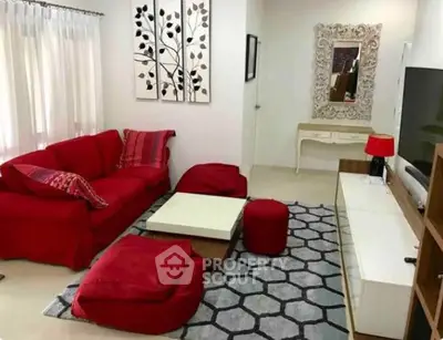 Stylish living room with vibrant red sofa, modern decor, and elegant wall art.