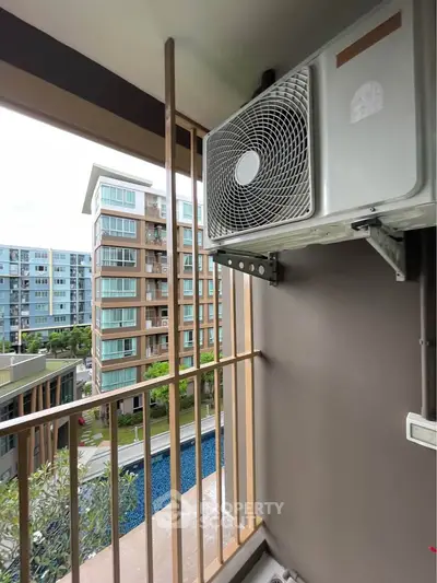 Modern apartment balcony with air conditioning unit and pool view