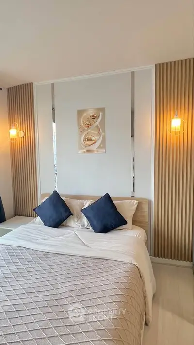 Elegant bedroom with modern lighting and cozy bedding in a stylish apartment.