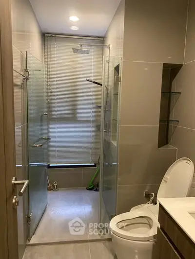 Modern bathroom with glass shower and sleek fixtures in a contemporary apartment.