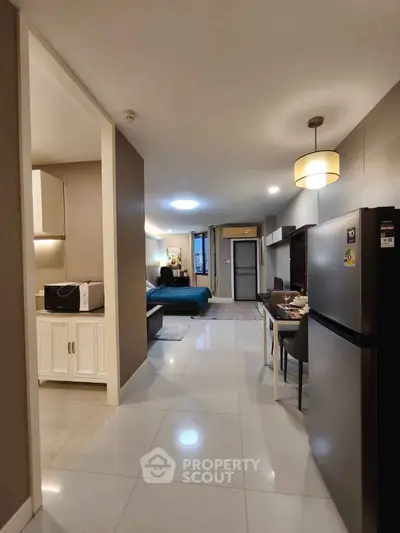 Modern open-plan apartment with sleek kitchen and cozy living area, perfect for urban living.