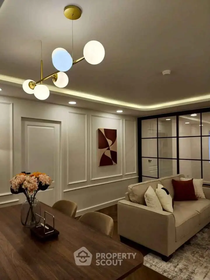 Elegant living room with modern lighting and stylish decor, featuring a cozy sofa and chic wall art.