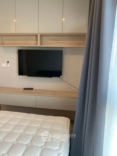 Modern bedroom with wall-mounted TV and stylish cabinetry