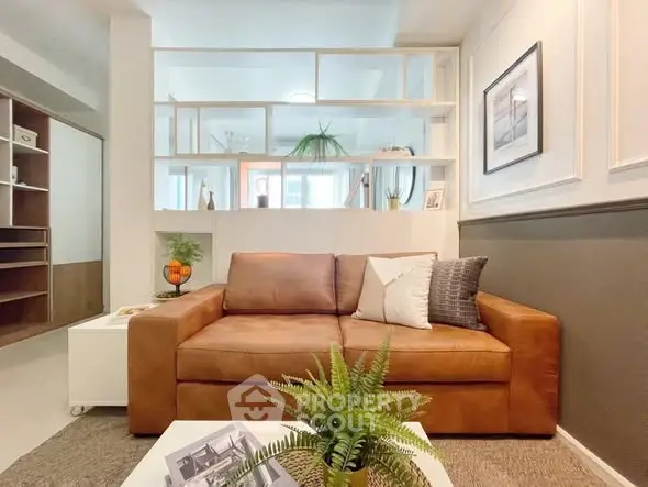 Stylish living room with leather sofa and modern decor in a cozy apartment.