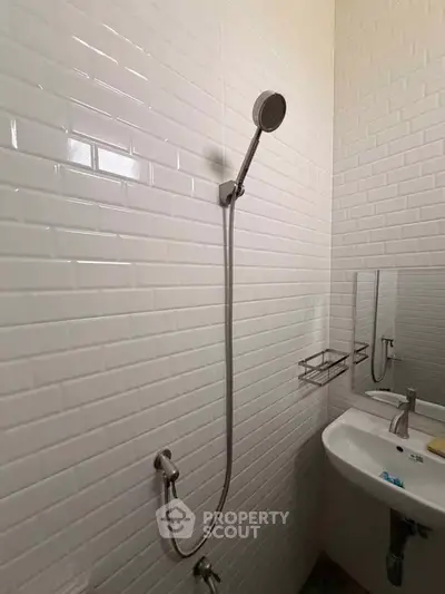 Modern bathroom with sleek showerhead and white subway tiles