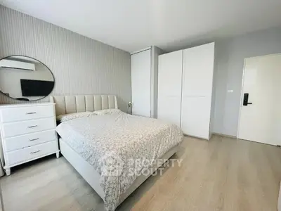 Spacious bedroom with modern decor and ample storage in a stylish apartment.