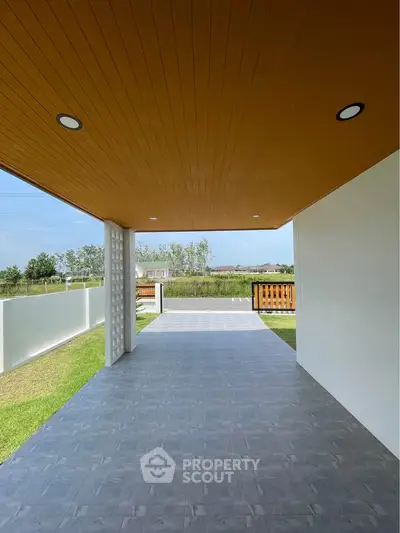 Spacious covered patio with modern design and scenic view, perfect for outdoor relaxation.