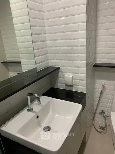Modern bathroom with sleek sink and stylish white subway tiles.